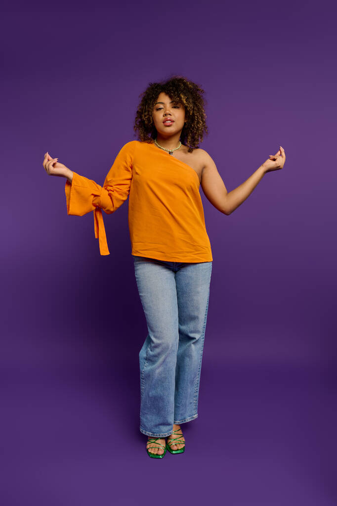 Afrikai amerikai nő narancssárga felső pózol stílus élénk háttér. - Fotó, kép