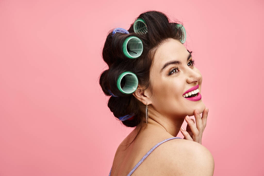 A woman with curlers in her hair striking a pose for a camera. - Photo, Image