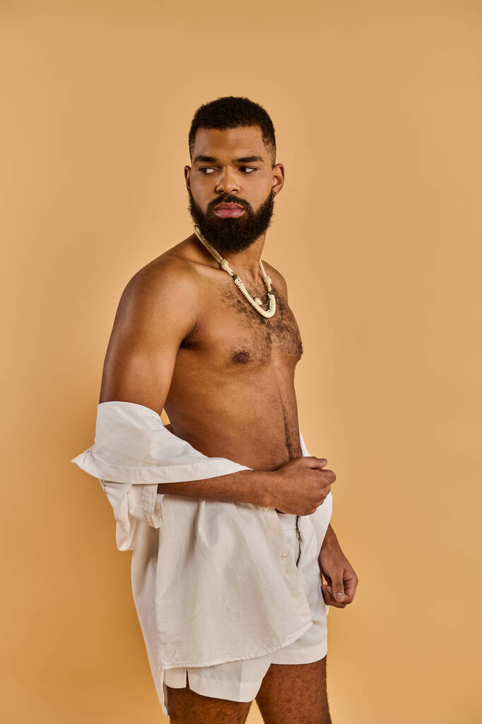 Um homem sereno com uma barba exuberante graciosamente adorna uma toalha branca nítida, exalando uma sensação de calma e relaxamento. - Foto, Imagem
