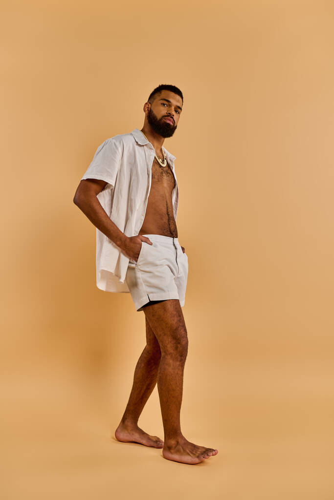 Ένας άντρας με γενειάδα να στέκεται γυμνός μπροστά σε μαυρισμένο φόντο, αποπνέοντας μια αίσθηση ελευθερίας και σύνδεσης με τη γη.. - Φωτογραφία, εικόνα