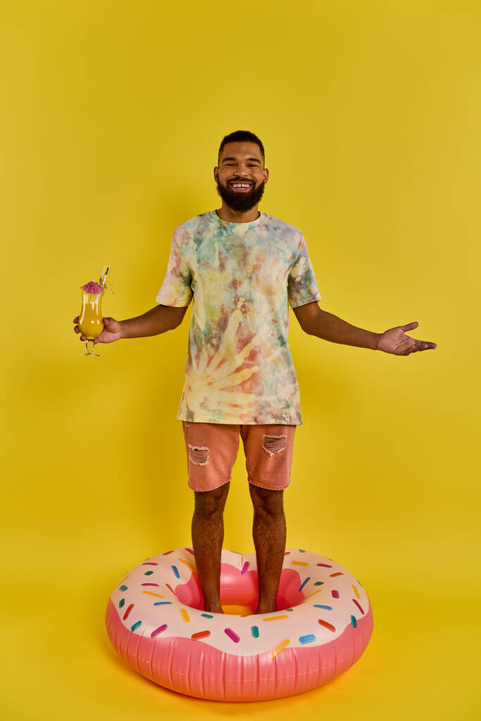 Ein Mann balanciert selbstbewusst auf einem riesigen Donut, trinkt in der Hand, in einer surrealen und skurrilen Szene. - Foto, Bild