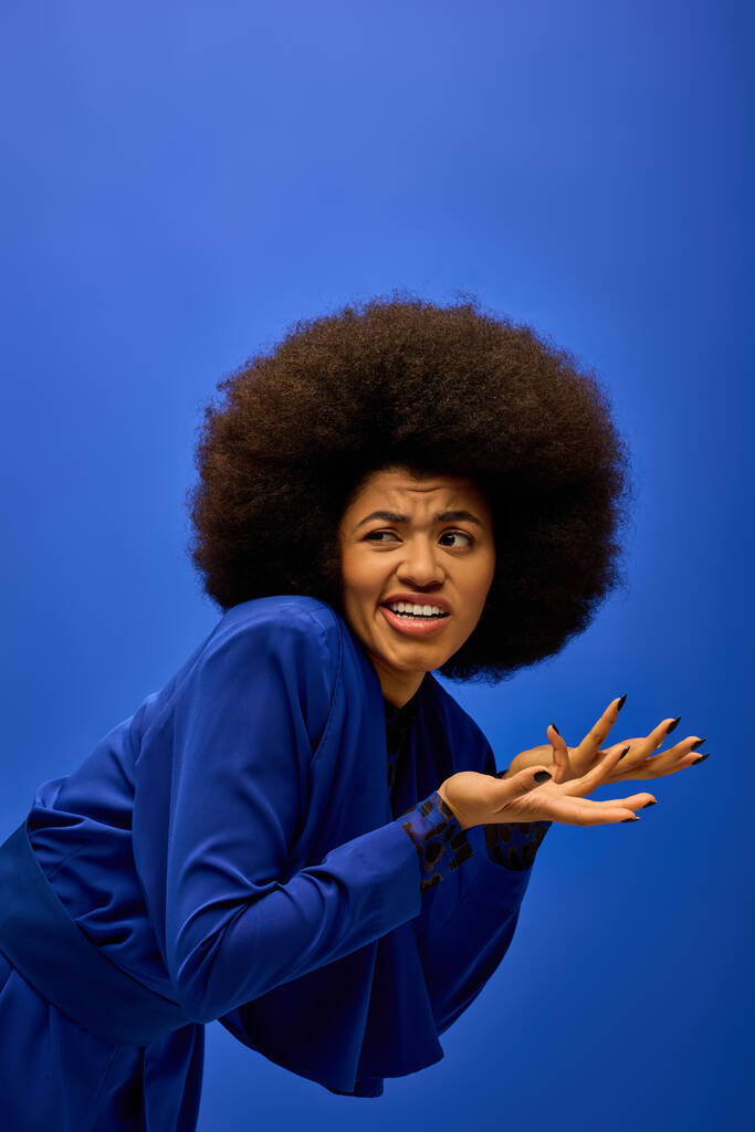 Mujer afroamericana de moda posando sobre un vibrante telón de fondo. - Foto, Imagen