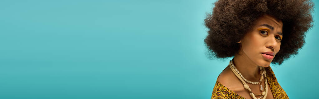 Stijlvolle Afro-Amerikaanse vrouw met krullend haar op een levendige achtergrond. - Foto, afbeelding