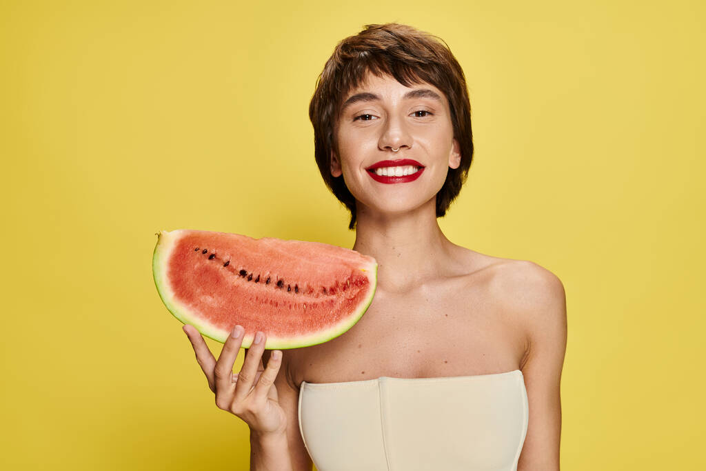Junge Frau hält Wassermelonenscheibe vor ihr Gesicht. - Foto, Bild