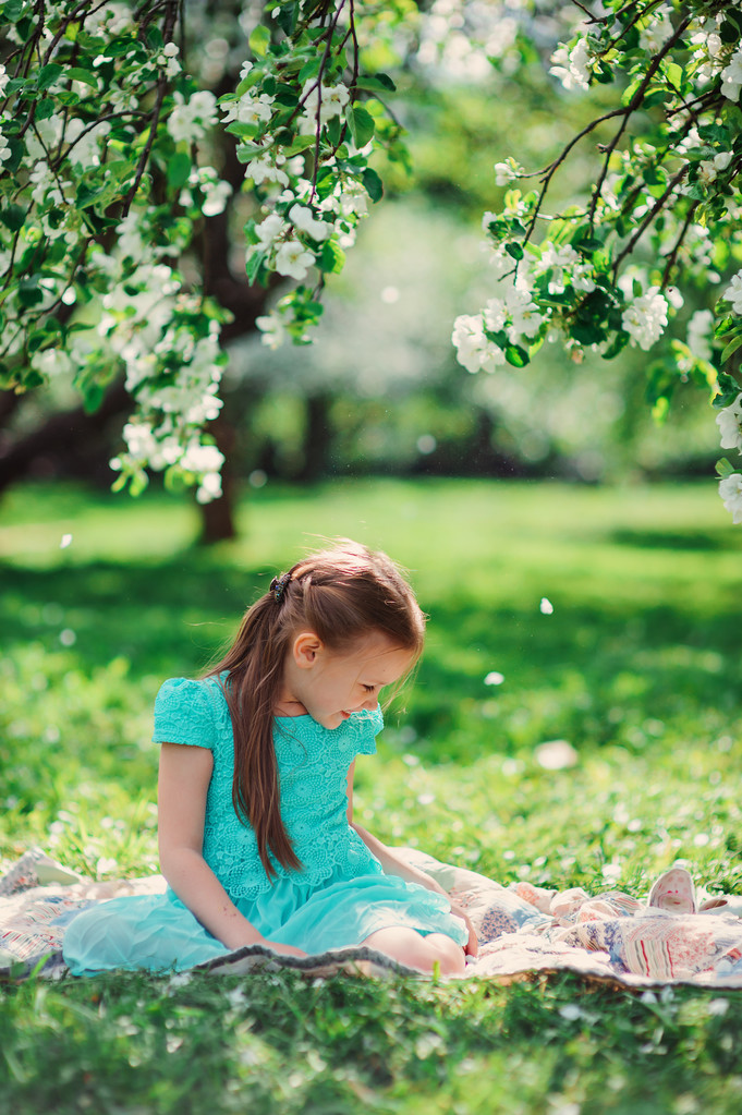 Счастливая девочка играет весной цветущий яблоневый сад
 - Фото, изображение