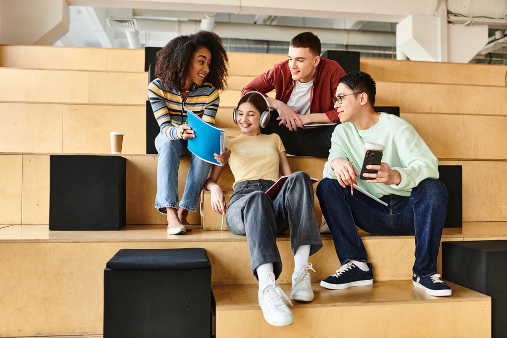 Multikulturelle Studenten, darunter ein afroamerikanisches Mädchen, sitzen zusammen auf Stufen und unterhalten sich lebhaft - Foto, Bild
