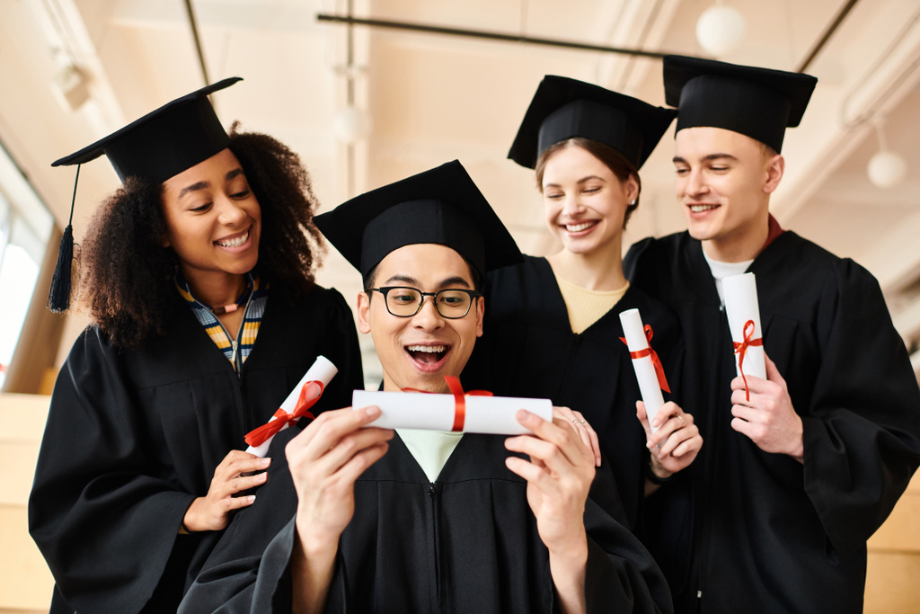 Um grupo diversificado de graduados em vestidos de graduação titulares de diplomas, celebrando a sua realização acadêmica em conjunto. - Foto, Imagem