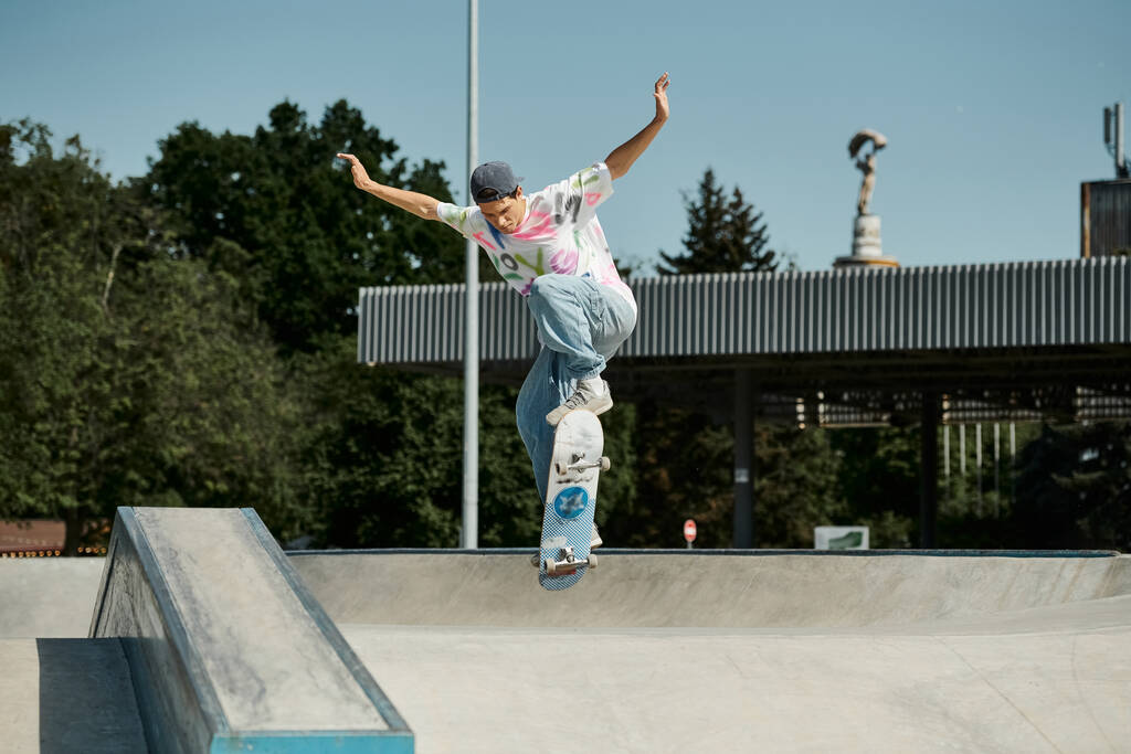 A young skater boy fearlessly riding a skateboard up the steep side of a ramp at an outdoor skate park on a sunny summer day. - Photo, Image