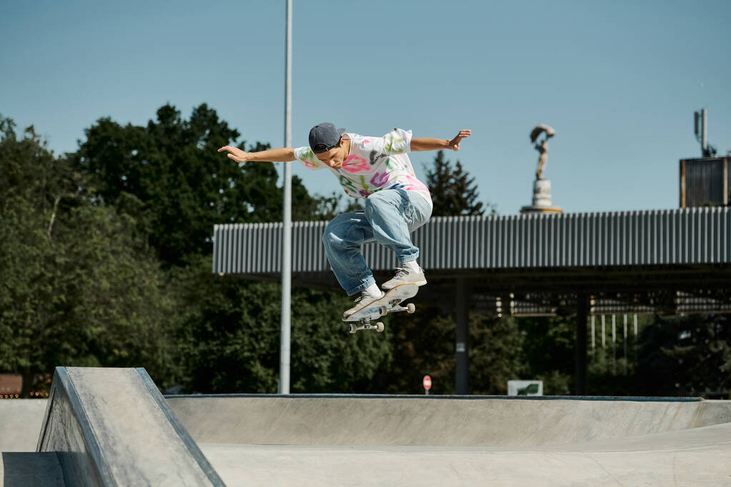 Mladý bruslař chlapec radostně skateboardy ve vzduchu v letním dni ve venkovním skate parku. - Fotografie, Obrázek