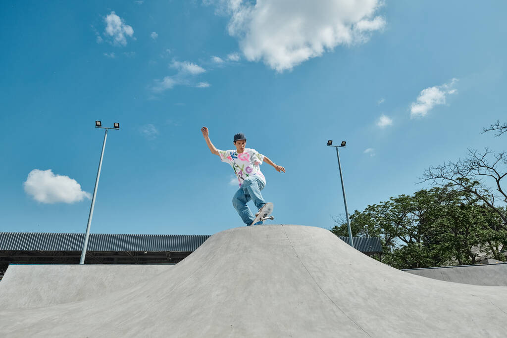 Un ragazzo skater è senza paura cavalcando il suo skateboard sul lato di una rampa vert in uno skate park in una giornata estiva soleggiata. - Foto, immagini