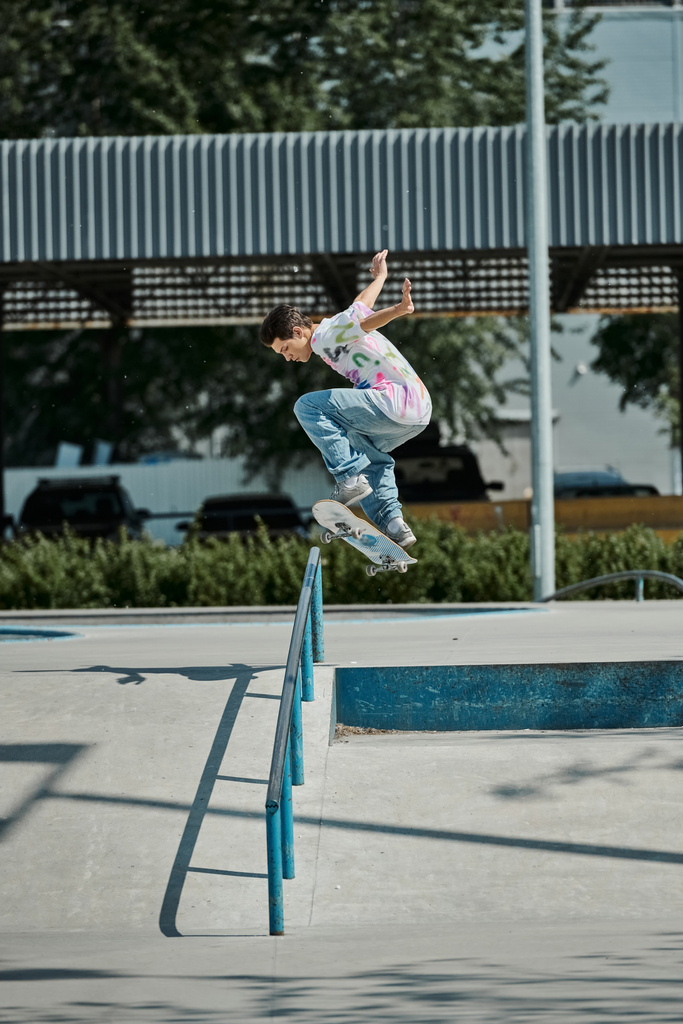 Un joven patinador vuela por el aire en un monopatín en un parque de skate en un día soleado de verano. - Foto, Imagen