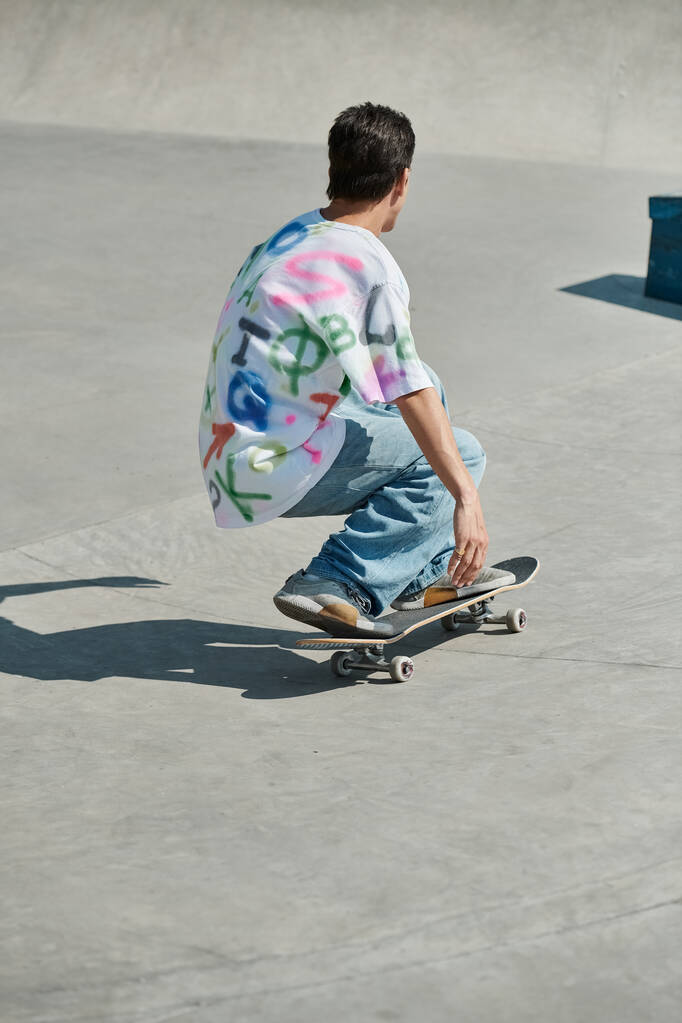 Молодой парень скользит по цементной рампе, демонстрируя мастерство и бесстрашие в летнем скейт-парке.. - Фото, изображение