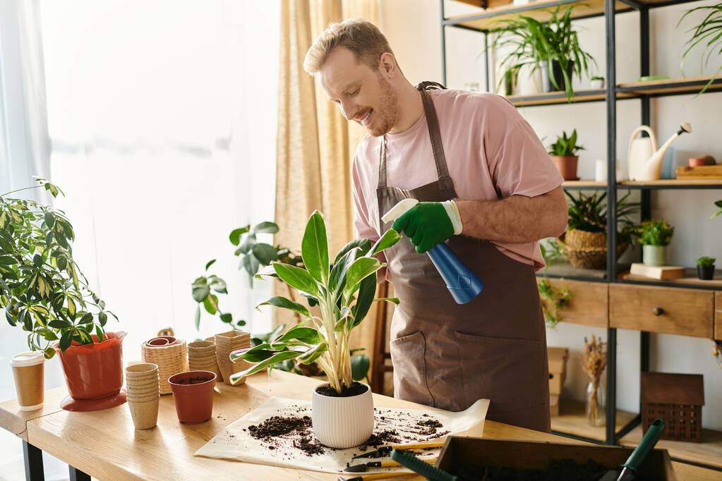 Un uomo tiene a una pianta in vaso su un tavolo in un piccolo negozio di piante, illustrando la cura e la crescita in un ambiente floreale. - Foto, immagini