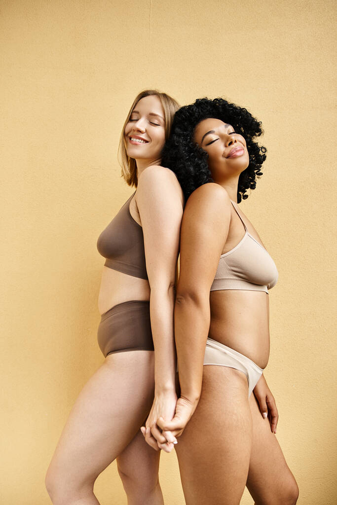 Kaksi kaunista naista seisoo luottavaisesti kodikas pastelli bikinit. - Valokuva, kuva