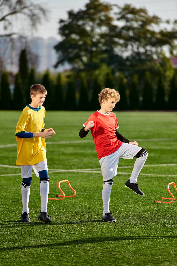 Dwóch energicznych młodych chłopców radośnie kopie piłkę nożną, pokazując swoje umiejętności i pasję do sportu.. - Zdjęcie, obraz