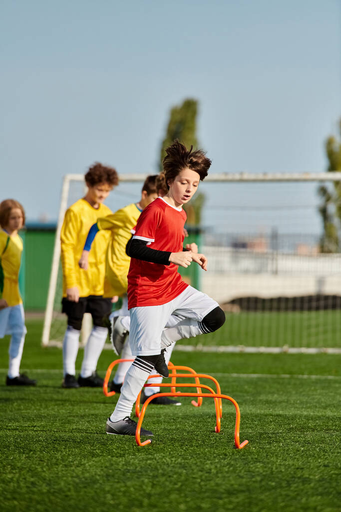 A dynamic group of young children engage in a spirited game of soccer, kicking the ball around the field with enthusiasm and teamwork. They are running, passing, and shooting towards the goal, showcasing their skills and camaraderie. - Photo, Image