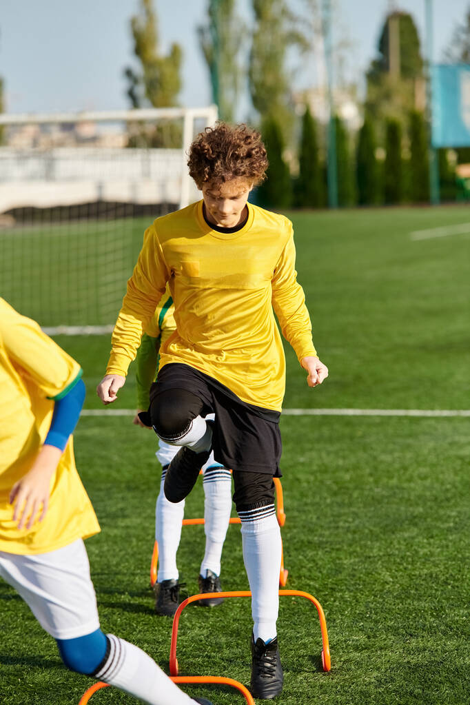 Δύο νέοι άνδρες συμμετέχουν σε ένα έντονο παιχνίδι ποδοσφαίρου, επιδεικνύοντας τις ικανότητές τους καθώς κάνουν ελιγμούς στην μπάλα κατά μήκος του γηπέδου και προσπαθούν να σκοράρουν ένα γκολ. - Φωτογραφία, εικόνα