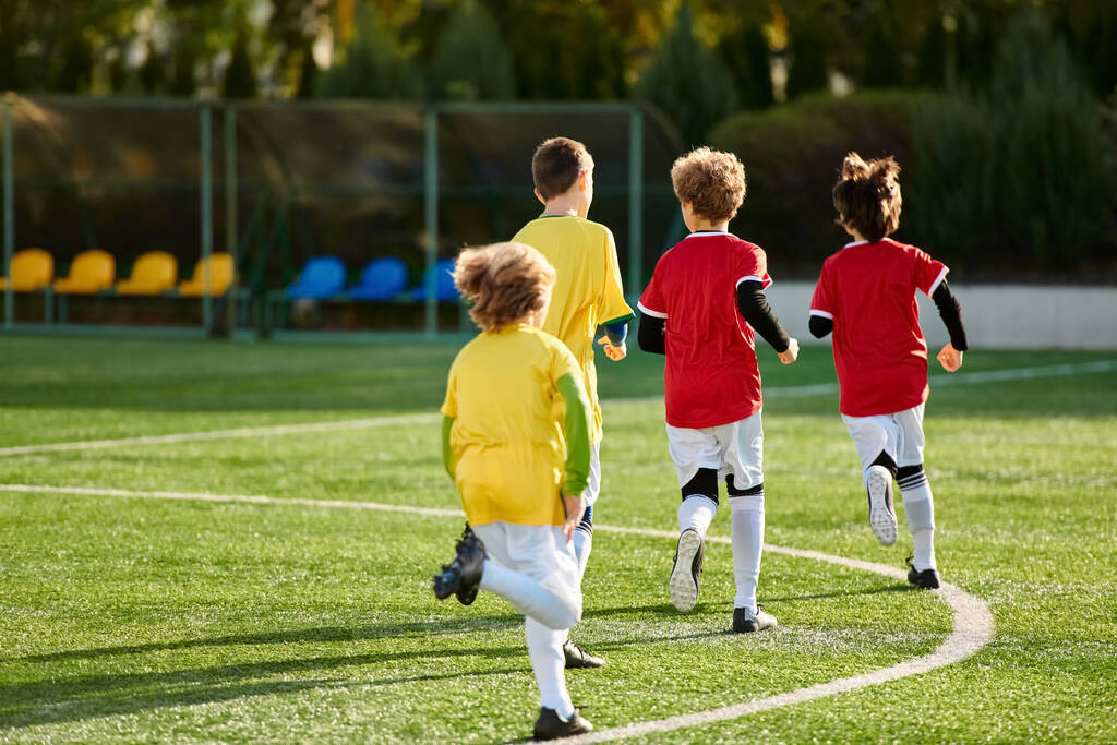 Una vivace scena di bambini che giocano a un vivace gioco di calcio, corsa, calci e tifo sul campo erboso con entusiasmo ed eccitazione. - Foto, immagini