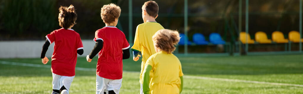 Eine Gruppe junger Jungen steht selbstbewusst auf einem Fußballplatz und blickt auf den saftig grünen Rasen darunter. Sie strotzen vor Energie und Enthusiasmus und sind bereit, das vor ihnen liegende Spiel zu gewinnen.. - Foto, Bild