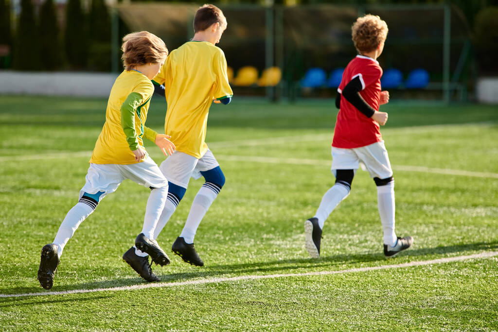 Μια δυναμική σκηνή ξεδιπλώνεται καθώς μια ομάδα νεαρών ανδρών συμμετέχουν σε ένα ζωηρό παιχνίδι ποδοσφαίρου, επιδεικνύοντας την ευκινησία, την ομαδικότητα και το ανταγωνιστικό τους πνεύμα στο γήπεδο.. - Φωτογραφία, εικόνα