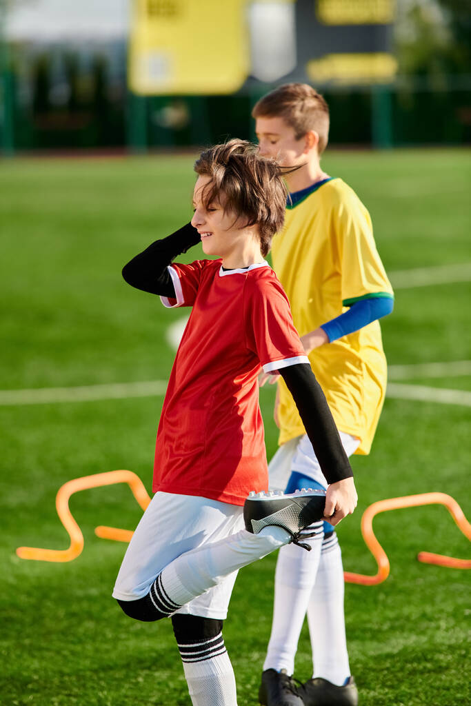 Двоє молодих чоловіків, енергійних і тріумфальних, стоять на футбольному полі після успішного матчу. Яскрава зелена трава контрастує зі своїми святковими виразами. - Фото, зображення