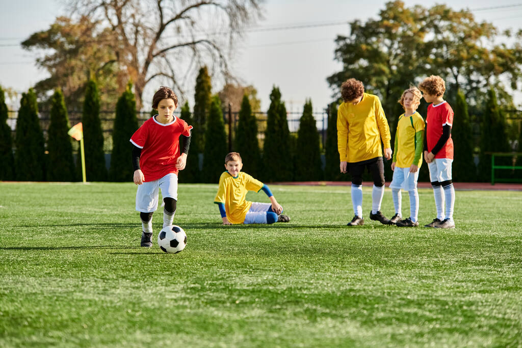 Grupa małych dzieci, pełna energii i entuzjazmu, zaangażowała się w porywającą grę w piłkę nożną. Dzieciaki biegają, kopią piłkę i pracują razem jako drużyna na trawiastym polu.. - Zdjęcie, obraz