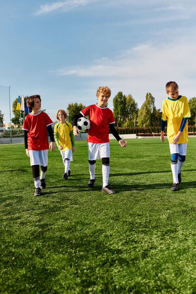Różnorodna grupa entuzjastycznych młodych chłopców stoi dumnie na szczycie boiska do piłki nożnej, patrząc na horyzont z determinacją i radością po meczu. - Zdjęcie, obraz