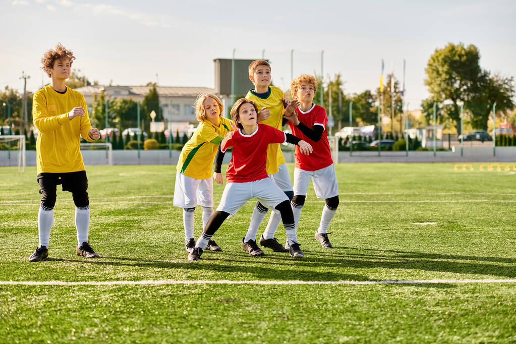 Разнообразная группа молодых людей излучает радость и триумф, объединившись на вершине футбольного поля, празднуя победу вместе. - Фото, изображение