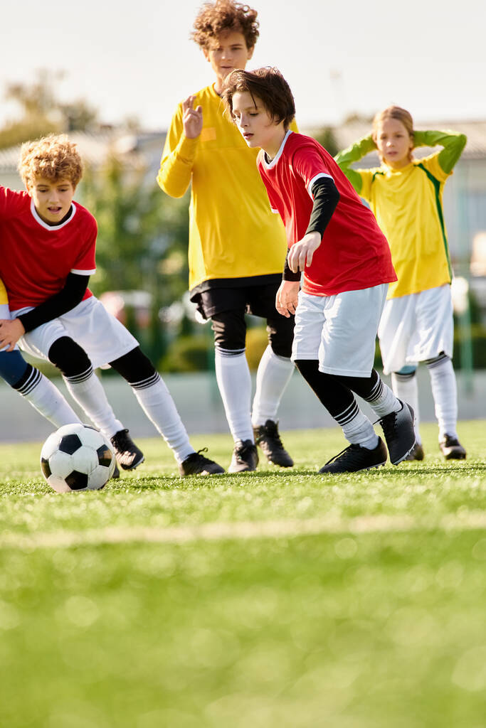 Μια ομάδα ενθουσιωδών παιδιών διαφόρων ηλικιών που παίζουν ποδόσφαιρο σε ένα χορταστικό πεδίο, κλωτσώντας την μπάλα, τρέχει, και γελώντας απολαμβάνοντας ένα φιλικό παιχνίδι μαζί. - Φωτογραφία, εικόνα