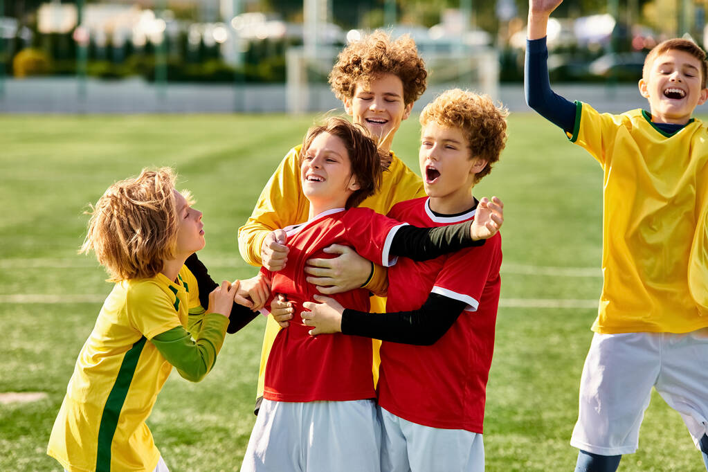 Группа энергичных маленьких детей торжествует на вершине футбольного поля, излучая волнение и радость после игры. Их лица сияют гордостью, когда они вместе празднуют победу.. - Фото, изображение