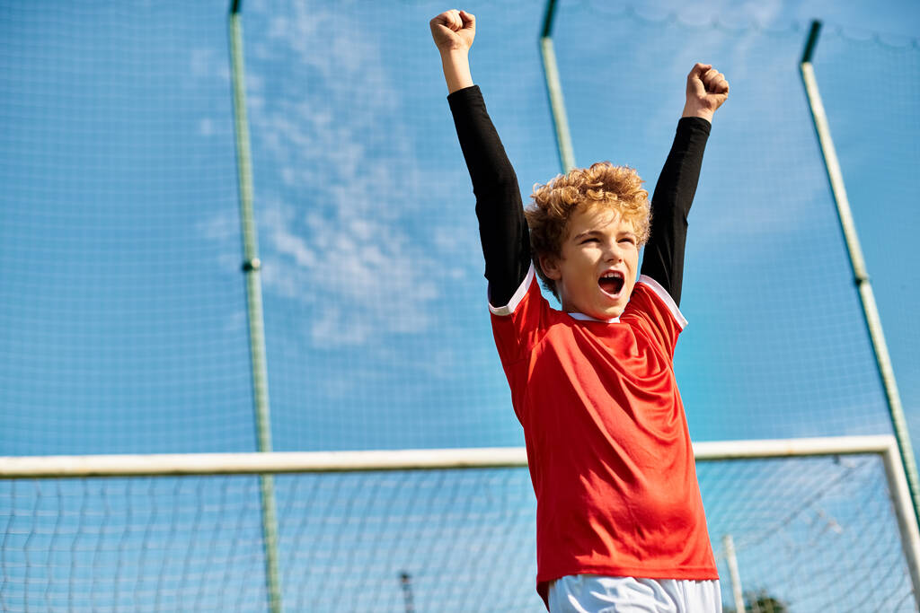 Nuori poika seisoo luottavaisin mielin tenniskentällä tennismaila kädessään. Hänen keskittynyt katseensa vihjaa hänen päättäväisyydestään ja intohimostaan peliin, kun hän valmistautuu palvelemaan tai palauttamaan pallon.. - Valokuva, kuva