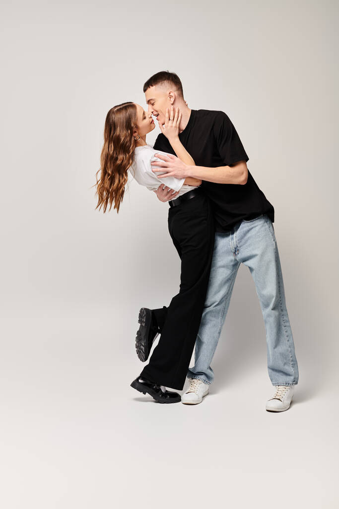 A man and woman share a passionate kiss in a studio setting, expressing love and tenderness in a moment of connection. - Photo, Image