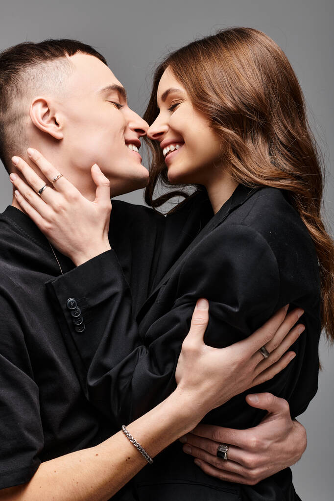 男性と女性,若いカップルは,灰色の背景に対して愛情深いジェスチャーで互いに抱き合っています.. - 写真・画像