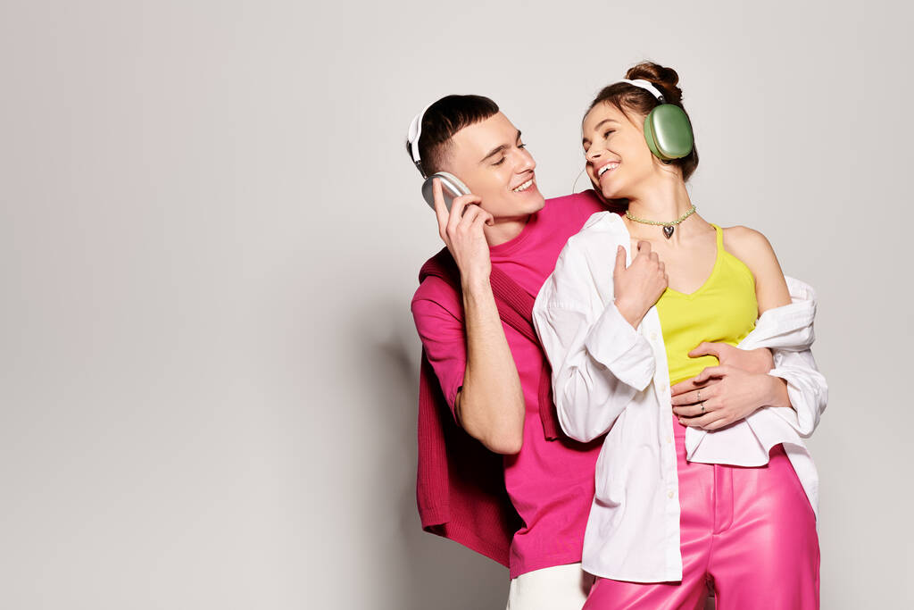 Un jeune couple élégant amoureux debout ensemble dans un studio, sur un fond gris. - Photo, image