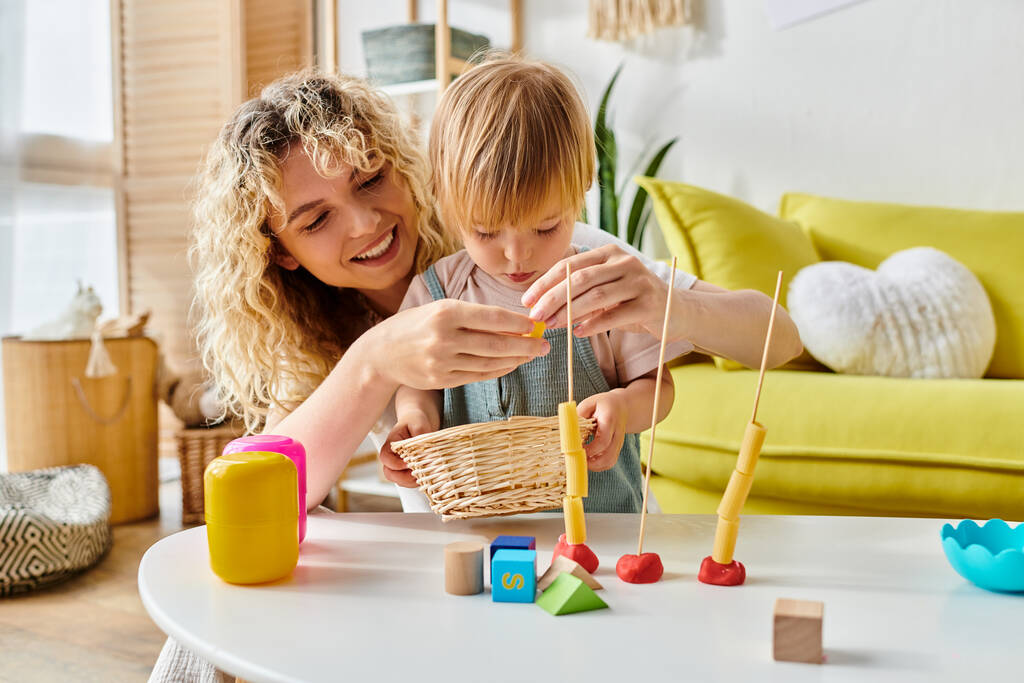 Nainen ja lapsi onnellisesti osallistuvat Montessorin opetusmenetelmään kotona. - Valokuva, kuva