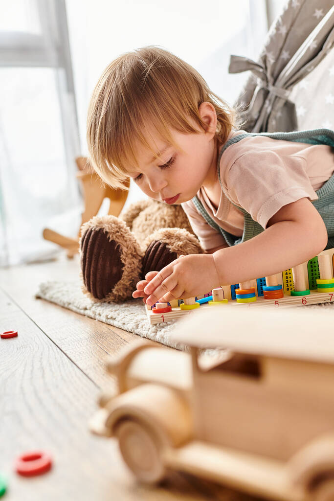 Kihara äiti katsoo, kun hänen lapsi tyttärensä leikkii iloisesti leluilla lattialla kotona, upotettuna Montessori-menetelmään.. - Valokuva, kuva