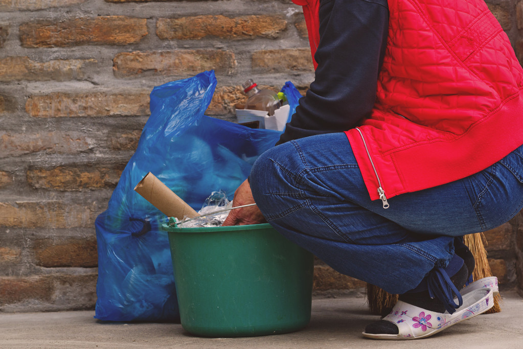 Mulher colocando lixo em lata e saco de plástico
 - Foto, Imagem
