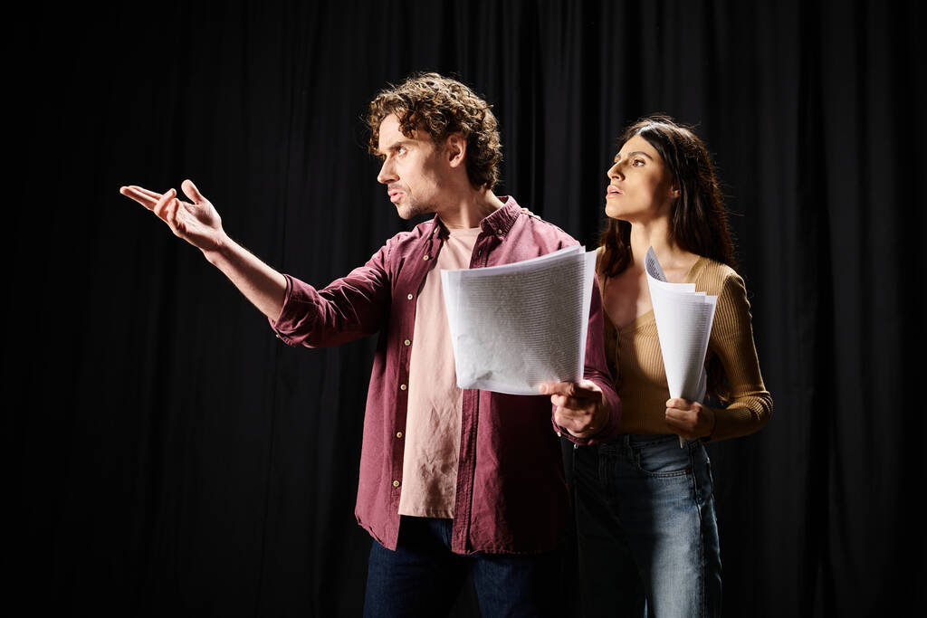 A man and woman rehearse together, holding papers. - Photo, Image