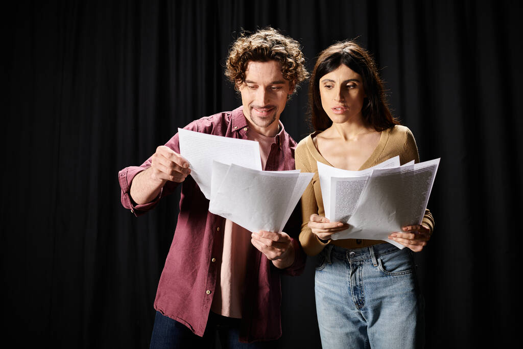 A man and woman stand, studying scripts together. - Photo, Image