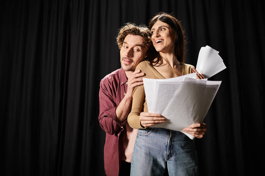 Ein Mann und eine Frau arbeiten zusammen und halten während einer Theaterprobe einen Zettel in der Hand. - Foto, Bild