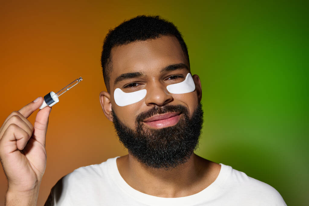 African american young man using eye patches and serum. - Photo, Image
