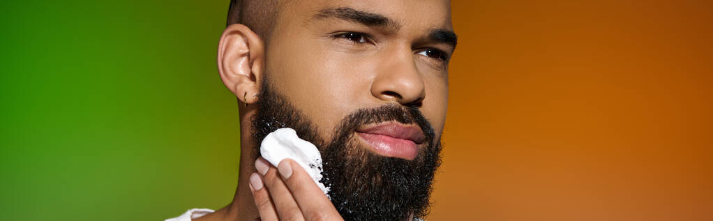 Afro-americano atractivo hombre usando crema de afeitar. - Foto, Imagen