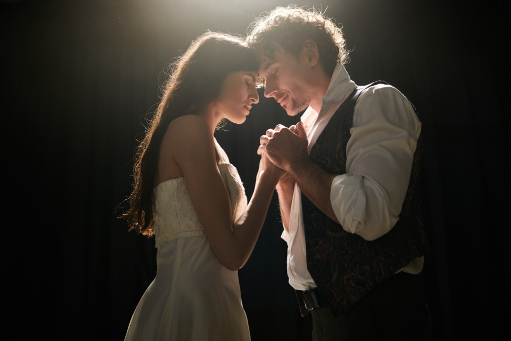 Um homem e uma mulher dançam graciosamente no teatro mal iluminado.. - Foto, Imagem