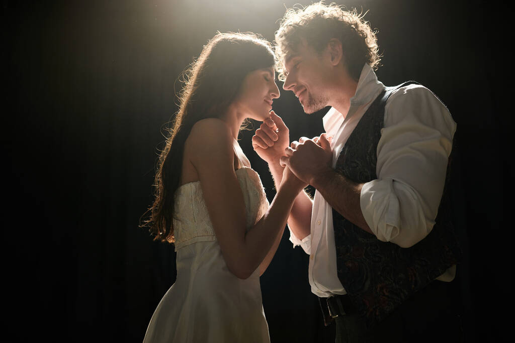 Homme et femme élégants dansent gracieusement ensemble dans un cadre de faible luminosité. - Photo, image