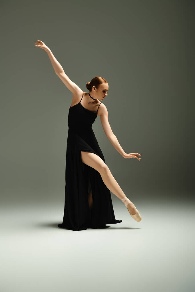 Siyah elbiseli genç ve güzel bir balerin zarif bir şekilde dans ediyor.. - Fotoğraf, Görsel