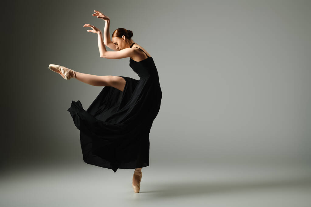 Nuori, kaunis ballerina mustassa mekossa tanssii tyylikkäästi. - Valokuva, kuva