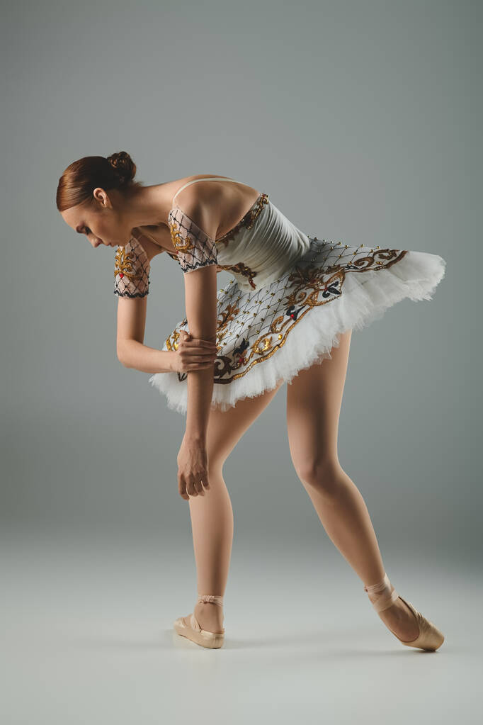 Молода, красива балерина танцює витончено в приголомшливій білій і золотій сукні. - Фото, зображення