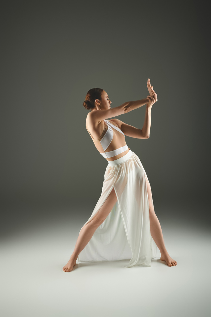 Elegante bailarina en vestido blanco golpea una pose - Foto, imagen