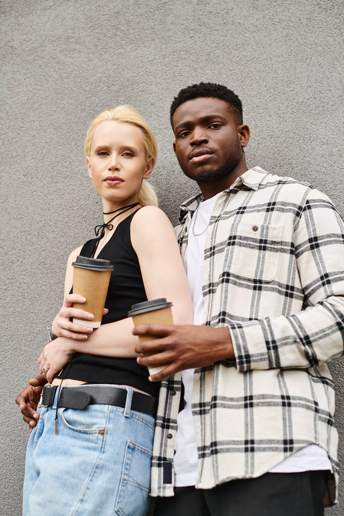 Een multiculturele man en vrouw die naast elkaar staan in een stedelijke straat en een moment van verbondenheid en saamhorigheid delen. - Foto, afbeelding
