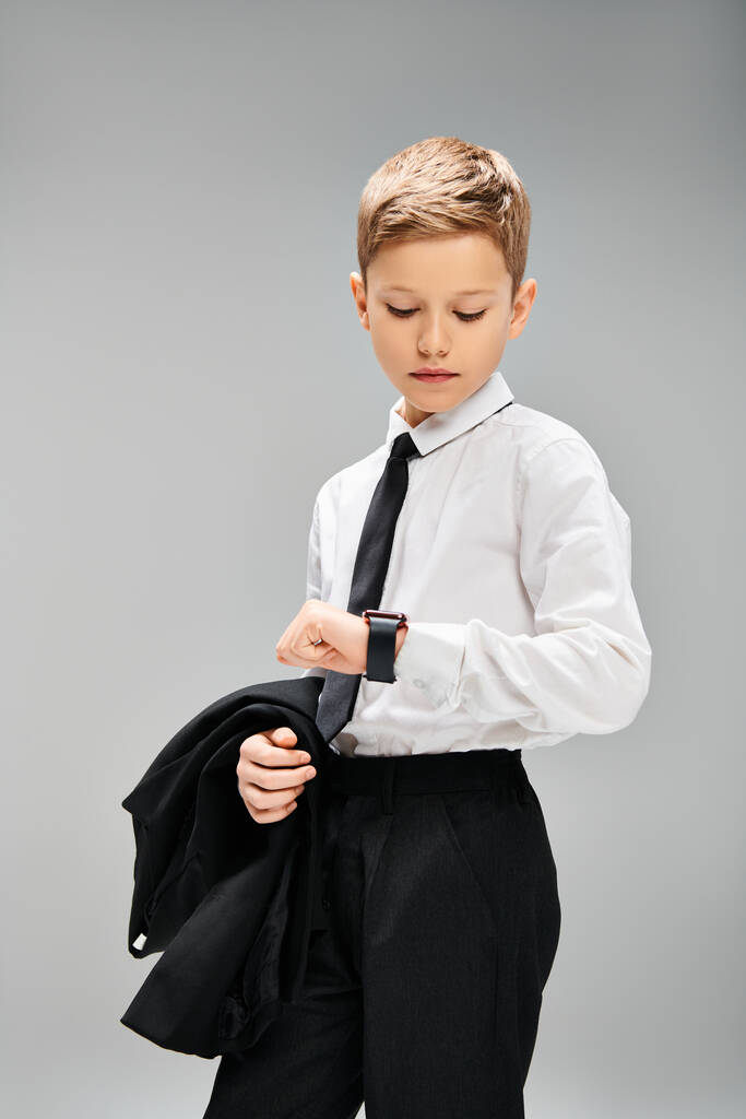 Imádnivaló kamasz fiú fehér ingben és fekete nyakkendő szürke háttér, áradó elegancia. - Fotó, kép